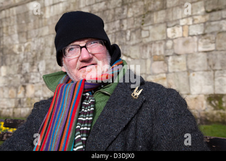 Chi osa vince il distintivo su vecchio soldato  persona senza casa a York, pensionato seduto ben avvolto per l'inverno. Yorkshire, Regno Unito Foto Stock