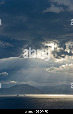 Drammatico il cielo sopra il mare e le montagne Foto Stock