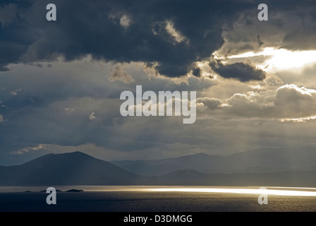 Drammatico il cielo sopra il mare e le montagne Foto Stock