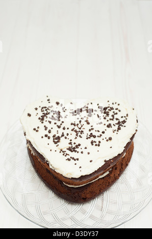 A forma di cuore torta al cioccolato con vaniglia e il burro di crema di farcitura di glassa Foto Stock