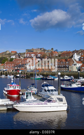 Imbarcazioni da diporto e imbarcazioni da pesca ormeggiate nel porto di Whitby, Whitby Abbey in vista sulla scogliera dietro, North Yorkshire Inghilterra Foto Stock