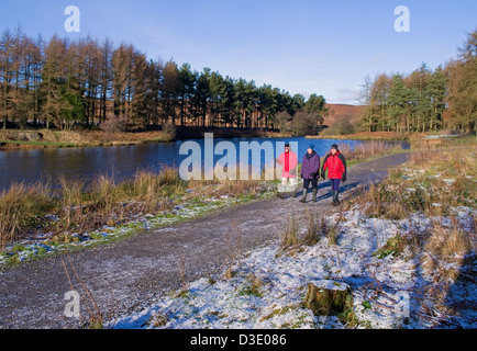 Tre gli escursionisti a Cod Beck serbatoio vicino Osmotherley, North York Moors National Park, North Yorkshire, il freddo inverno pieno di sole del giorno Foto Stock