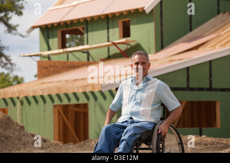 Uomo con lesioni al midollo spinale in una sedia a rotelle al suo nuovo accessibile home in costruzione Foto Stock