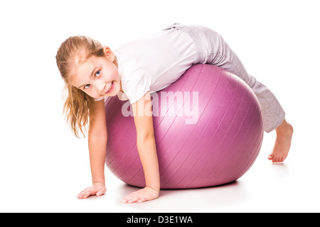 Ragazza sportiva su un montare la sfera jumping isolato su bianco Foto Stock