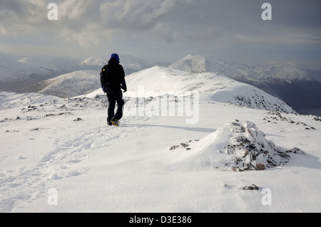 Inverno in montagna in Scozia. Maschio di Walker sul vertice di Sgorr nam Fiannaidh in Glencoe Foto Stock
