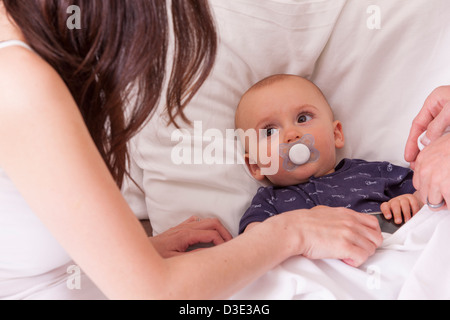 I genitori di mettere il loro figlio a letto Foto Stock