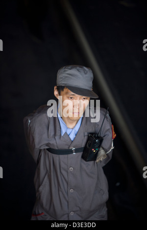 XIMING miniera di carbone, TAIYUAN, Cina - Agosto 2007: un controller di caricamento di orologi di un treno in avvicinamento. Foto Stock