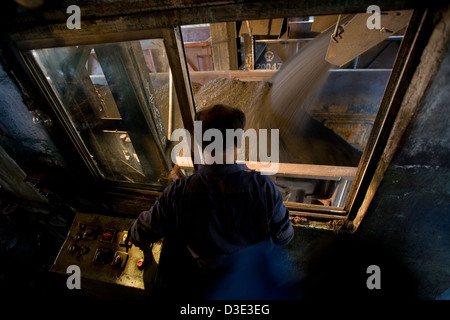 XIMING miniera di carbone, TAIYUAN, Cina - Agosto 2007: il caricamento di carbone operatore esegue il carbone in vuoto carrelli ferroviari per la consegna alle stazioni di alimentazione al nord. Foto Stock