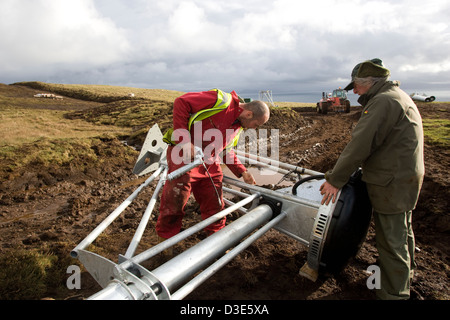 Isola di Eigg, Scozia - 30 ottobre 2007: Joe Brown si applica al grasso di alcune parti in movimento della testa di turbina. Foto Stock