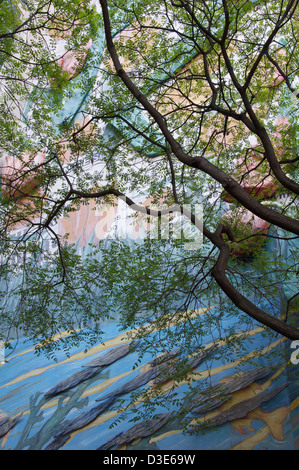 Un dettaglio di un murale chiamato "Les Marchés" visto attraverso le foglie e rami di un albero di acacia, vicino alla Borsa di Parigi. La Francia. Foto Stock