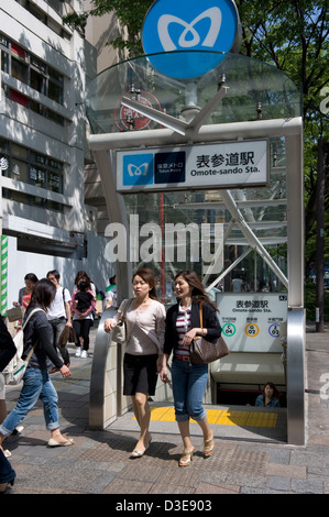 Due donne emergono dall'ingresso della metropolitana di Tokyo lungo via Omotesando-dori nell'elegante quartiere di Shibuya, Tokyo, Giappone. Foto Stock