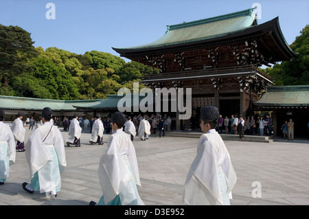 Lo Shintoismo sacerdoti marzo in una processione attraverso il cancello principale di Meiji Jingu durante una cerimonia religiosa a Tokyo in Giappone. Foto Stock