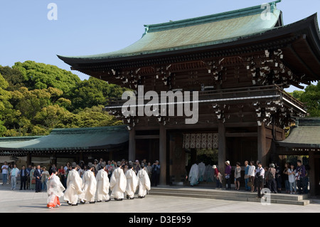 Lo Shintoismo sacerdoti marzo in una processione attraverso il cancello principale di Meiji Jingu durante una cerimonia religiosa a Tokyo in Giappone. Foto Stock