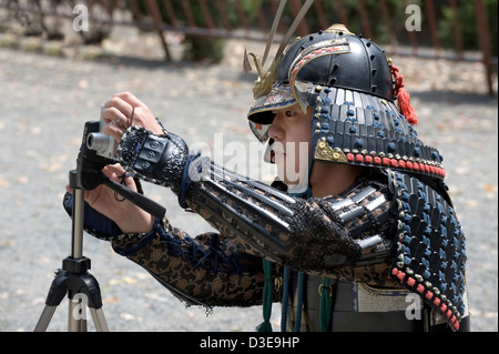 Un giovane domenica samurai imposta la sua macchina fotografica per un tiro commemorativo durante un festival a Odawara Castello nella Prefettura di Kanagawa. Foto Stock