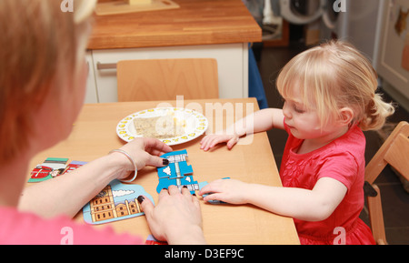 La mamma a giocare con la sua figlia toddler facendo un puzzle. Foto Stock