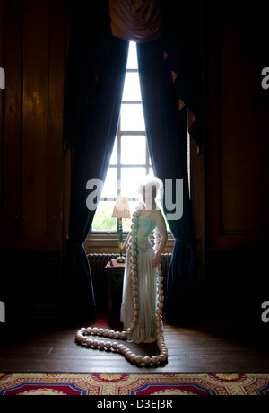 Una principessa strega queen LADY donna in rosso e rosa castello con un gigante collana di perle in una fiaba surreale impostazione di fantasia Foto Stock