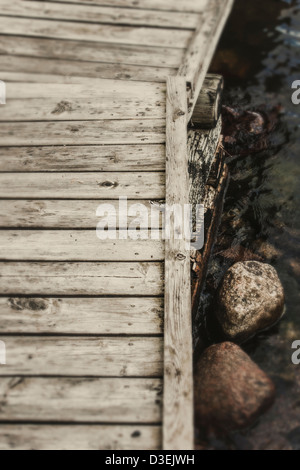 Tranquillo paesaggio con vuoto pontile in legno, mare e rocce in bianco e nero Foto Stock