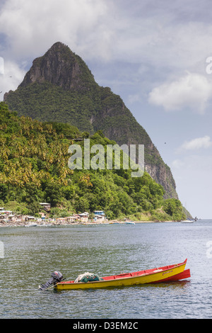 Una piccola barca da pesca si trova al di ancoraggio con il Petit Piton a 2461 ft (739 m) il terzo punto più alto sulla St Lucia) in background Foto Stock