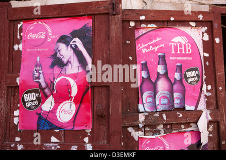 Madagascar, Ambositra Sandrandahy sun-sbiancata lingua malgascio coca cola e THB tre cavalli birra poster su porta Foto Stock