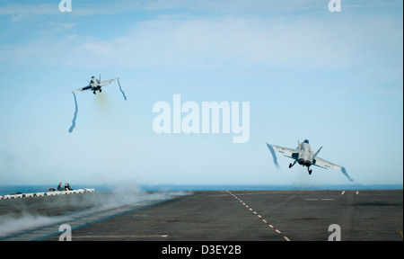 US Navy F/A-18C calabroni decollare dal Navy US classe Nimitz super carrier USS Carl Vinson ponte di volo in corso Febbraio 16, 2013 nell'Oceano Pacifico. Foto Stock