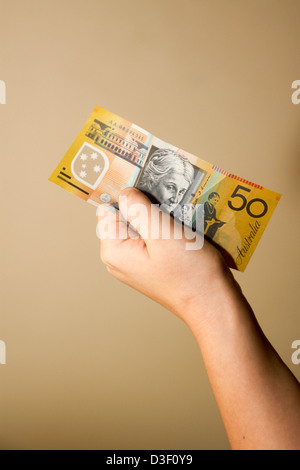 La mano della bambina azienda $50 50 Australiano Dollaro nota banca Foto Stock