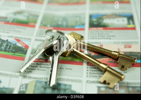 Close up, macro, micro fotografia delle chiavi di casa su annunci di immobili in vendita. Conceptual Agenti Immobiliari fotografia. Foto Stock