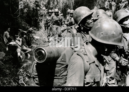 USULATAN, EL SALVADOR, Marzo 1982: vescovo salvadoregno dell esercito Brigata Atlacatl di pattuglia vicino Usulatan passare una famiglia il lavaggio della biancheria. Foto Stock