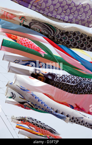 Colorate koinobori giapponese carp streamers per ciascun membro della famiglia in onda in sole contro un cielo blu sul ragazzo del giorno 5 maggio. Foto Stock
