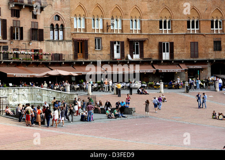 I turisti si sono riuniti intorno alla Fonte Gaia in Piazza del Campo a Siena Italia Foto Stock