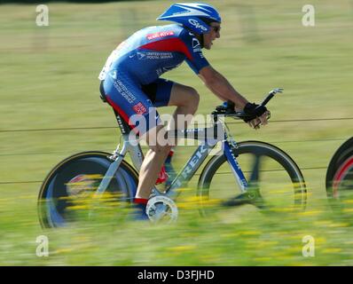 (Dpa) - US il ciclista Lance Armstrong (L), quattro volte vincitore del tour e capitano della squadra di noi Servizi postali, cavalca il suo passato di biciclette verdi campi durante la quarta tappa del Tour de France a Joinville, Francia, 9 luglio 2003. La squadra vince il cronometro sulla quarta tappa del Tour de France che copre una distanza di 69 chilometri dalla cittadina francese di Joinvill Foto Stock