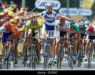 (Dpa) - ciclista italiano Alessandro Petacchi (C) del team Fassa Bortolo alza le braccia in segno di vittoria come egli attraversa la linea del traguardo per vincere la terza tappa del Tour de France, Saint-Dizier, 8 luglio 2003. La terza fase ha portato da Charleville-Mezieres a Saint Dizier oltre una distanza di 167,5 km. Foto Stock