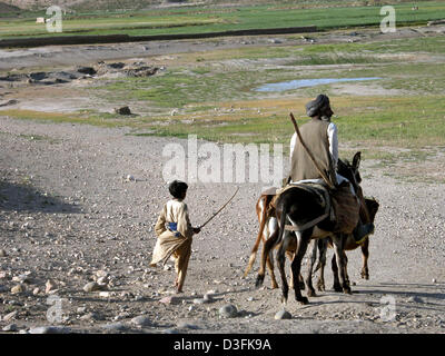 (Dpa) - Un uomo afghano e suo figlio di ritorno da Kundus sulla strada settentrionale verso la frontiera afgana al Tagikistan, 17 aprile 2004. Foto Stock