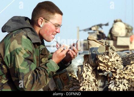 (Dpa) - US marina il Tenente Michael Woodrum della terza luce Amoured Battaglione di ricognizione (terza LAR) rade di fronte a un piccolo hand-held specchio vicino ad Dianiyah in Iraq meridionale, 1 aprile 2003. Marines americani a prepararsi per il progresso decisivo su Bagdad dopo giorni di riposo. Foto Stock