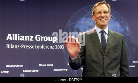 (Dpa) - Michael Diekmann, nuovo CEO di Allianz AG, i servizi finanziari e il fornitore di servizi assicurativi, sorge di fronte al logo aziendale e sorrisi durante una conferenza stampa a Monaco di Baviera, Germania, 20 marzo 2003. Diekmann continua la politica della società di fornire servizi finanziari integrati da mantenendo la perdita di Dresdner Bank. L'Allianz AG vuole raccogliere nuovi capitali in miliardi Foto Stock