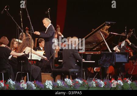 (Dpa file) - British violinista e direttore Yehudi Menuhin conduce l'Orchestra del Schleswig-Holstein Fesitval musica che è accompagnato dal tedesco direttore e pianista Justus Frantz ad Amburgo, Germania, 28 luglio 1991. Siamo nati Yehudi Menuhin divenne famoso in tutto il mondo come un violinista prima il suo ventesimo compleanno. Ha studiato a Parigi con il violinista e compositore George Enesco wh Foto Stock