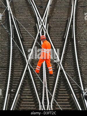 (Dpa) - Un lavoratore delle ferrovie tedesche (Deutschen Bahn AG) attraversa i binari di un cantiere di smistamento a Monaco di Baviera, Germania, 12 marzo 2003. L'azienda ferroviaria tedesca è pressurizzato a causa del suo prezzo controverso sistema. Secondo il magazine tedesco 'Spiegel' (mirror), il volume di affari di ferrovie tedesche nei primi due mesi del 2003 era del 7 percento inferiore rispetto a quanto in precedenza si aspettano Foto Stock