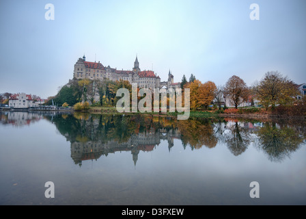 Schloss Sigmaringen in Baden Wurttemberg, Germania si riflette nelle acque del Danubio superiore su ancora una sera d'autunno. Foto Stock