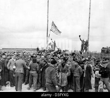 (Dpa file) - Camp prigionieri sorriso e un onda che noi bandiera come le truppe americane a liberare il campo di concentramento nazista di Dachau, Germania, 30 aprile 1945. Dachau fu il primo campo di concentramento, eastablished il 22 marzo 1933, una scarsa sei settimane dopo Adolf Hitler era salito al potere. Foto Stock