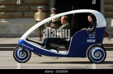 (Dpa) - Una donna gode di una corsa in una cabina Velotaxi ad Amburgo, 15 aprile 2003. Tre linee di questi a pedale di cabine di condotta sarà operativo durante la stagione estiva in Amburgo come una rapida alternativa per il quotidiano il traffico delle ore di punta. Un altro vantaggio del Velotaxi è che essa non causa né gas di scarico né rumore. Foto Stock