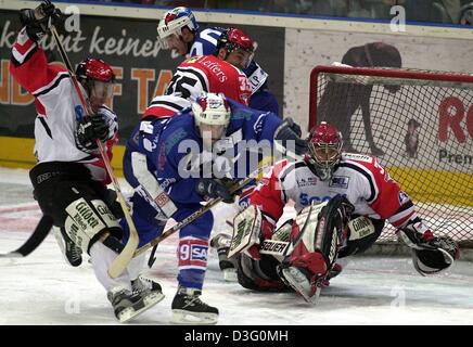 (Dpa) - Mannheim il riscontro canadese Mike Kennedy (C) trys affermare se stesso contro la colonia centro del giocatore Tino Boos (L) mentre Colonia ci del portiere Chris Rogles (R) blocca il modo in cui l'obiettivo durante l'hockey su ghiaccio Adler Mannheim (Eagle Mannheim) contro Koelner Haie (Colonia squali) presso i play-off semifinali della Deutsche Eishockey-Pokal (Campionato tedesco ice hocke Foto Stock