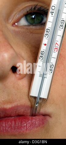 (Dpa) - Una donna malati con l'influenza prende la temperatura con un termometro che indica più di quaranta gradi Celsius, a Francoforte, 28 febbraio 2003. Foto Stock