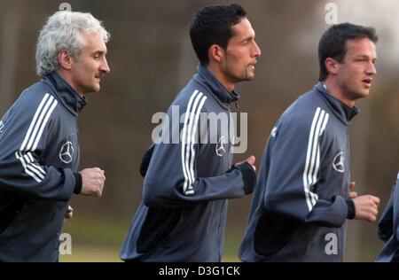 (Dpa) - Rudi Voeller (L), la nazionale tedesca allenatore di calcio, corre con i suoi avanti Kevin Kuranyi (C) e Fredi BOBIC durante il corso di formazione in Herzogenaurach, Germania, 25 marzo 2003. La Germania dovrà affrontare la Lettonia nel prossimo campionato europeo partita di qualificazione. Foto Stock