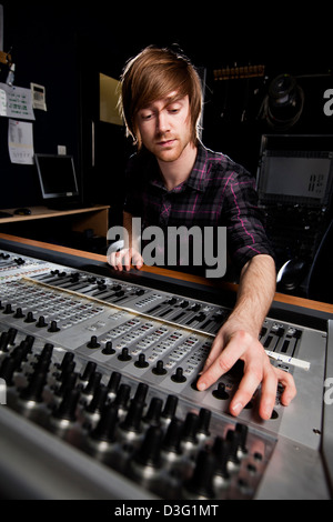 Ingegnere del suono utilizzando un studio console di mixaggio. Il fuoco selettivo sulla scrivania del suono. Foto Stock