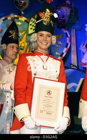 (Dpa) - Tedesco super model Heidi Klum, vestito in 'Funkischer uniforme" (sparky uniforme), pone con il suo certificato di nomina lei come 'reservire sparky-tenente' dal carnevale club 'Die Roten Funken" (rosso) scintille a Colonia, Germania, 1 marzo 2003. A Carnevale lunedì, il culmine della stagione di carnevale a Colonia, prenderà parte alla sfilata di carnevale e gettare la caramella fro Foto Stock