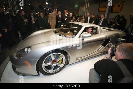 (Dpa) - Walter Roehrl, tedesco ex campione del mondo di rally car racing, siede in Porsche è di nuovo modello 'Carrera GT' a Ginevra l 'Automobilesalon', la vettura mostra e fiera, a Ginevra, Svizzera, 3 marzo 2003. Il 'Automobilesalon' è la prima evidenziare nella corrente europea anno di business per i costruttori e i progettisti. 265 espositori saranno presenti circa 900 brand Foto Stock