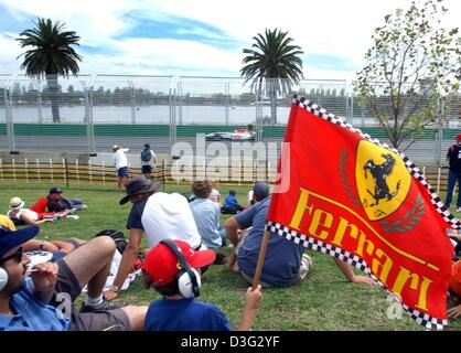 (Dpa) - Un ragazzo sventola una bandiera della Ferrari come spettatori guarda la prima formula una formazione qualificante sul Albert Park Race Track in Melbourne, 7 marzo 2003. La Australian Grand Prix scollegherà la stagione di Formula Uno il 9 marzo 2003 a Melbourne. Foto Stock