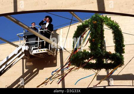 (Dpa) - i falegnami di avere un drink per celebrare il tradizionale topping-out cerimonia del quasi finito padiglione tedesco presso l'international horticultural show di Rostock, Germania settentrionale, 26 febbraio 2003. La mostra sarà aperta al pubblico dal 25 aprile al 12 ottobre 2003. Foto Stock