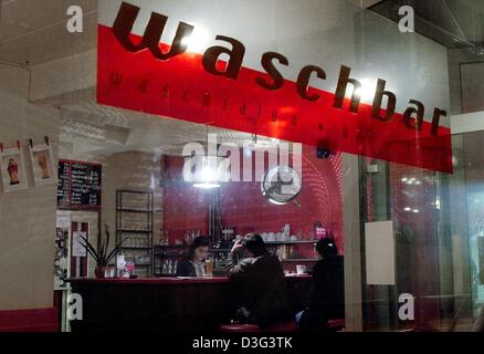 (Dpa) - i clienti e visitatori di sedersi a un bar ad una lavanderia a gettoni in Ruesselsheim, Germania, 18 febbraio 2003. Una lampada a forma di lavatrice della canna è sospeso verso il basso dal soffitto. Al di sopra della barra è appeso un cartello che recita "Washbar'. Gli artisti locali sono state eseguendo la lavanderia a gettoni, il 'Waschbar', per quasi due anni. Esso funziona anche come spazio espositivo per le loro opere di Foto Stock