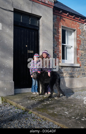 Due ragazze con Irish Wolfhound al di fuori di una zona rurale cottage in Irlanda Foto Stock
