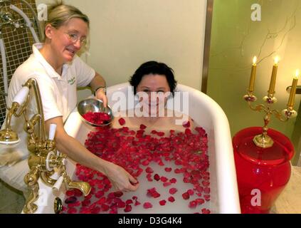(Dpa) - La testa del beauty farm, Birgit Storbeck, distribuisce i pedali è salito su una sostanza lattiginosa in una vasca da bagno dove una giovane donna si rilassa, presso il wellness hotel Maritim Kaiserhof nella località balneare di Heringsdorf, Germania settentrionale, 19 novembre 2003. La cosiddetta 'Kaiserbad' (imperatore del bagno) è composto da acqua di mare, il latte di capra, miele e oli diversi. Foto Stock